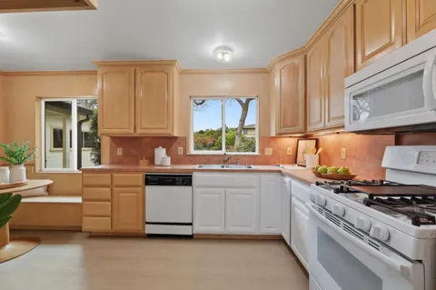 a kitchen with stainless steel appliances white cabinets and a stove top oven