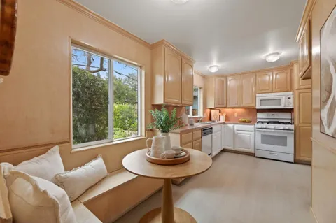 a kitchen with stainless steel appliances a table and chairs