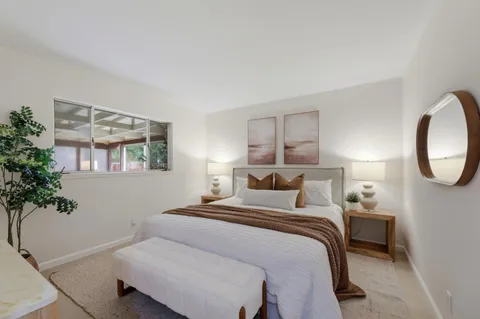 a bedroom with a large bed and a potted plant