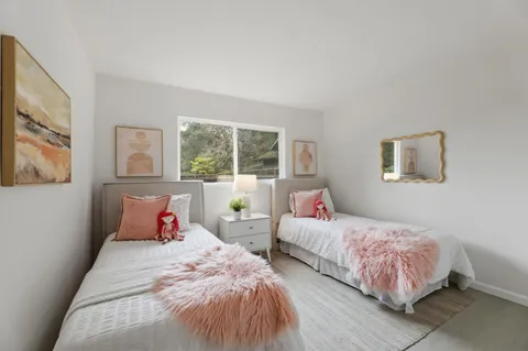 a bedroom with two beds and a large window