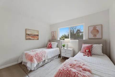 a bedroom with two beds and a painting on the wall