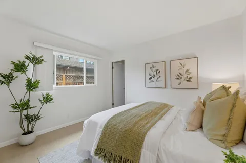 a bedroom with a bed and a potted plant