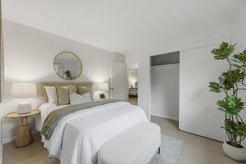 a bedroom with bed and a potted plant