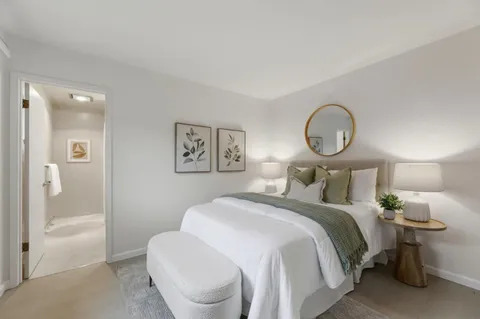 a bedroom with a bed and a painting on the wall