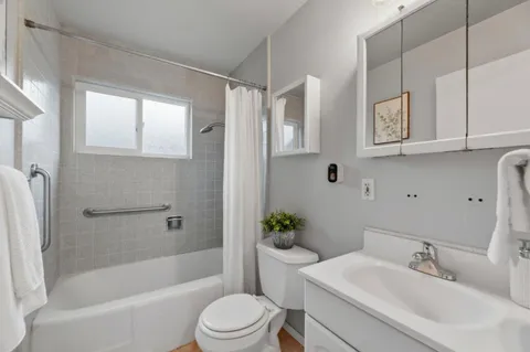 a bathroom with a bathtub shower sink and toilet