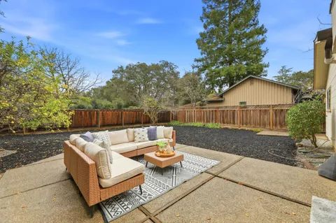 a view of a patio with couches table and chairs and potted plants