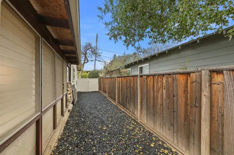 a view of a pathway of a house with wooden fence