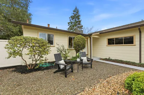 a backyard of a house with table and chairs