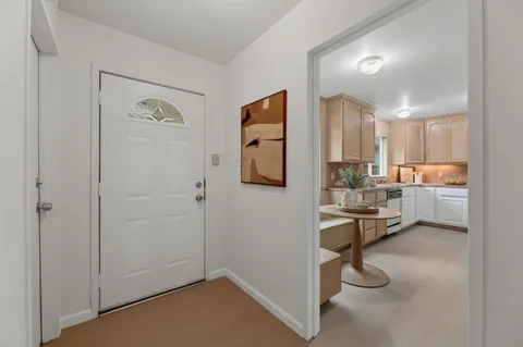 a kitchen with a refrigerator and white cabinets