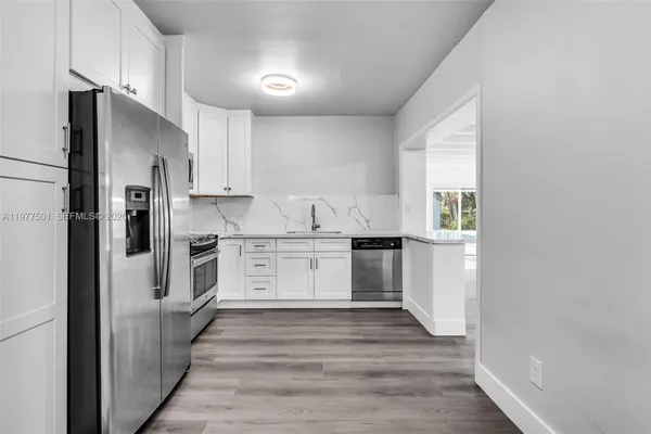 a kitchen with white cabinets and stainless steel appliances