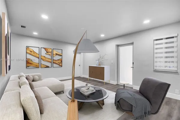 a living room with furniture and a wooden floor