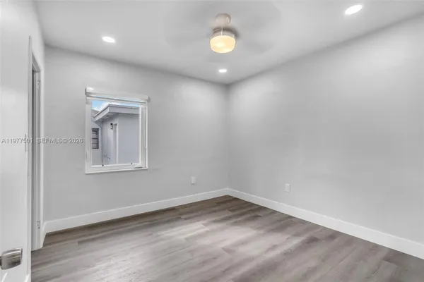 an empty room with a window and wooden floor