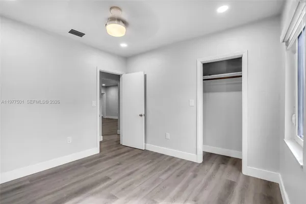 a view of empty room with wooden floor