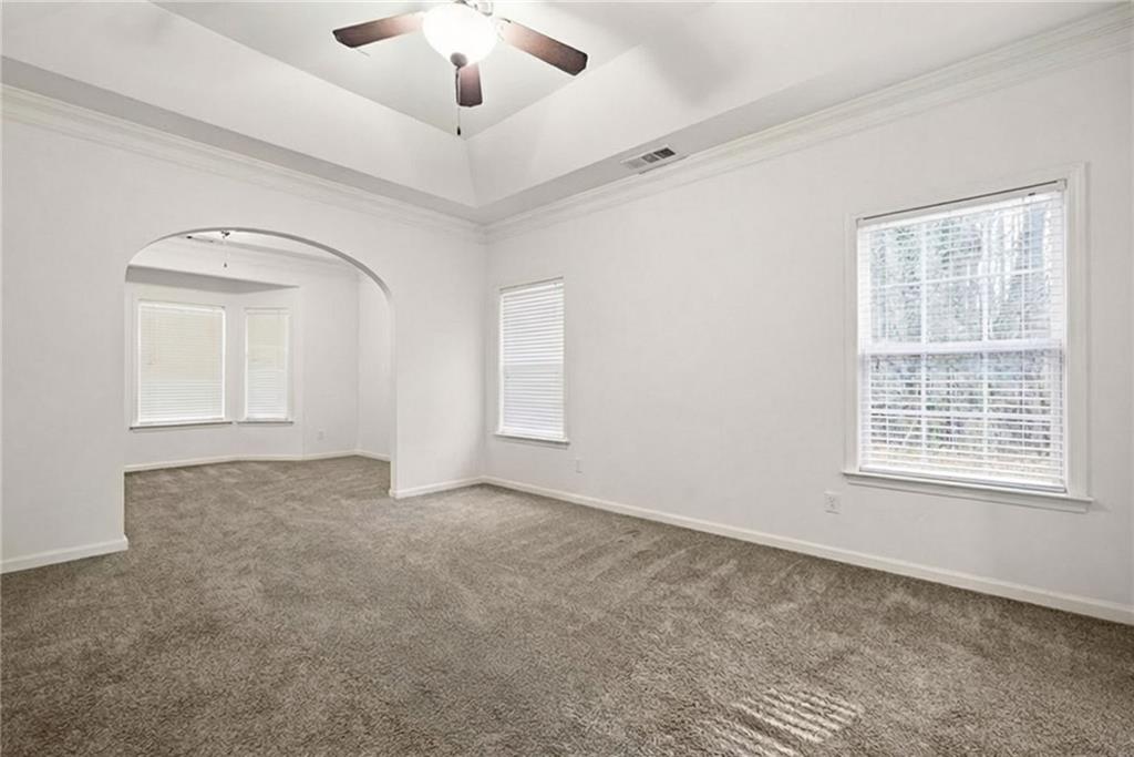 3155 Esplanade Circle Southwest Atlanta, GA 30311 - Photo 10 of 23 an empty room with chandelier fan and windows