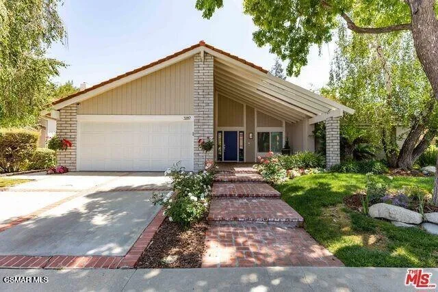 a front view of house with a garden