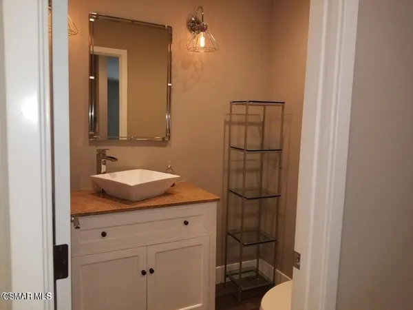 a bathroom with a granite countertop sink mirror vanity and toilet
