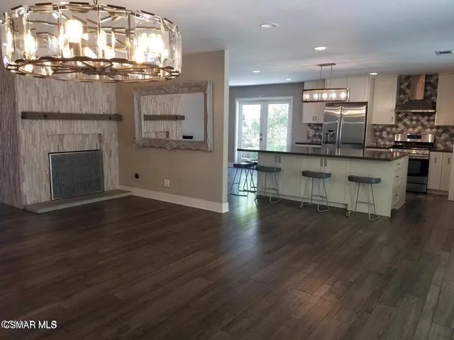 a open kitchen with white cabinets and wooden floor