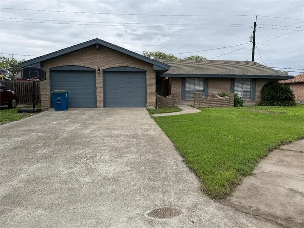 a front view of a house with a garden and plants