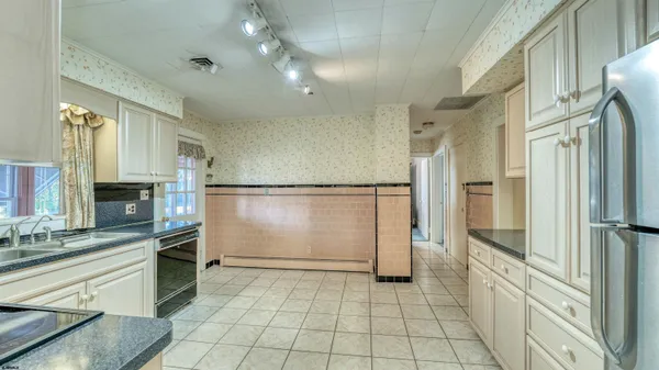 a kitchen with stainless steel appliances granite countertop a stove top oven a sink dishwasher and a refrigerator