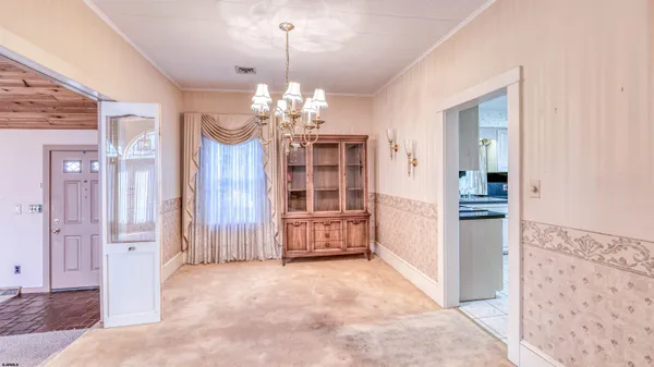 a view of a hallway with wooden floor and chandelier