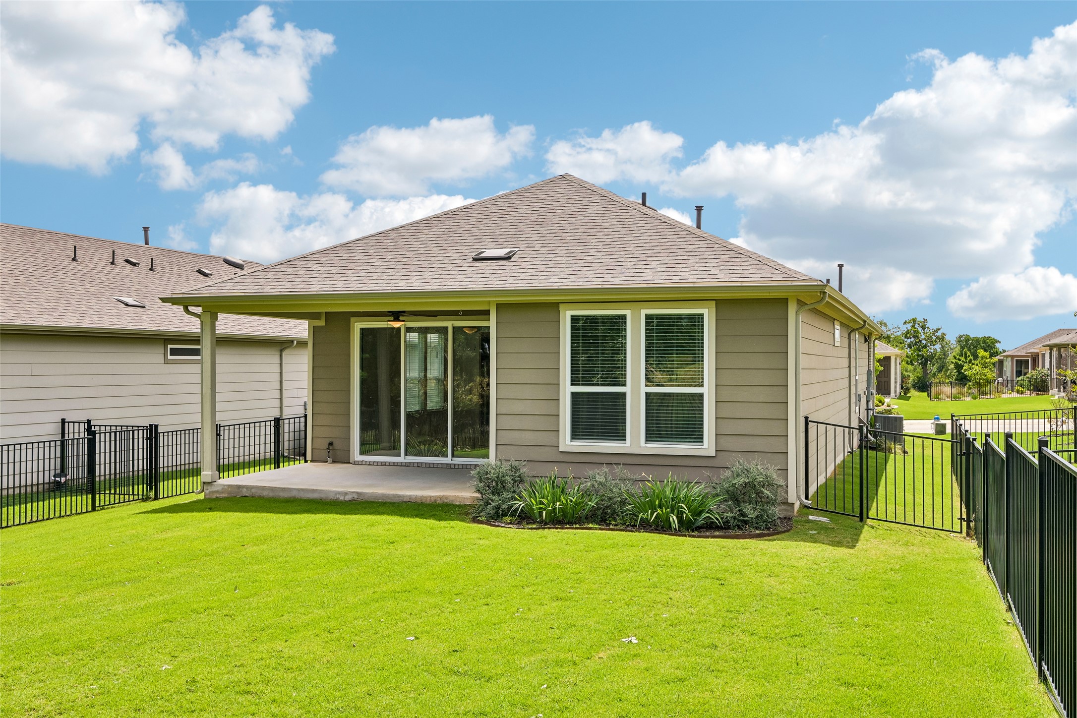 401 Yorktown Street Georgetown, TX 78633 - Photo 35 of 38 Expansive lawn area featuring a covered patio, sliding glass door access, and a metal fence enclosure