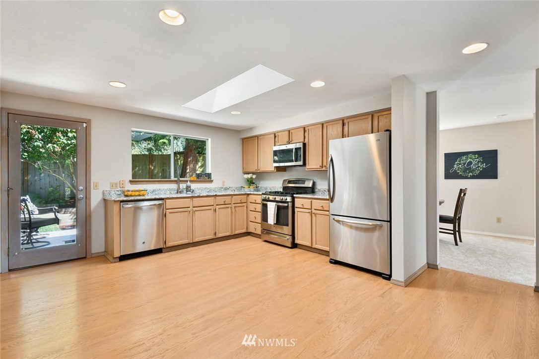 3225 208th Place Southeast Bothell, WA 98021 - Photo 6 of 28 a kitchen with white cabinets and stainless steel appliances