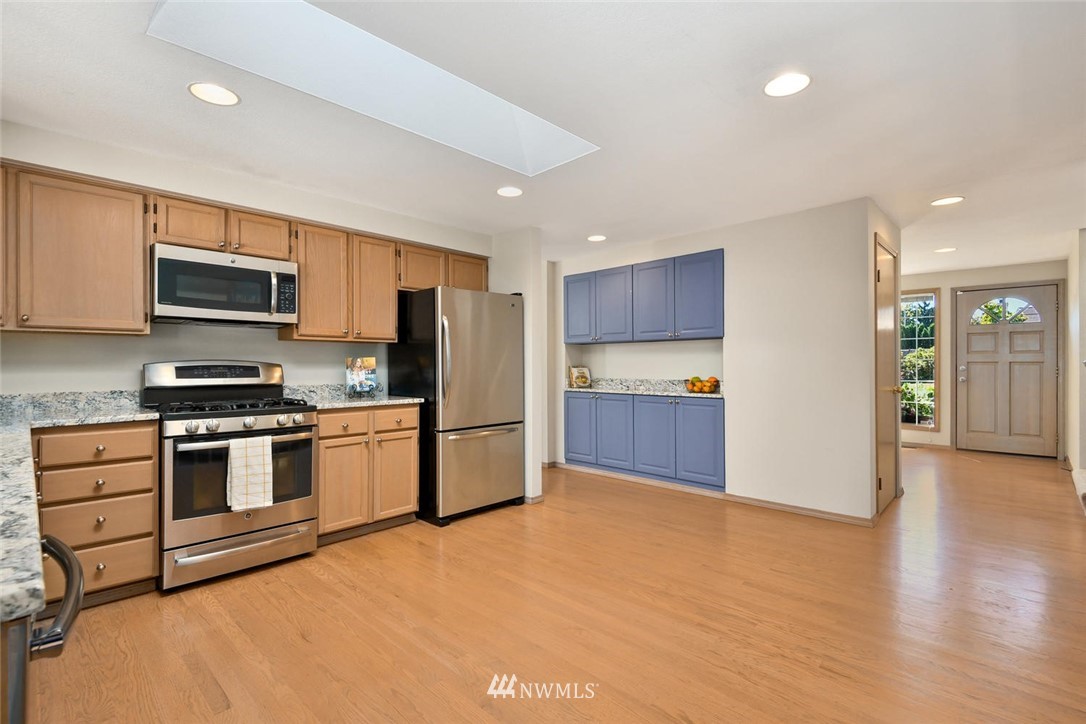 3225 208th Place Southeast Bothell, WA 98021 - Photo 7 of 28 a kitchen with stainless steel appliances kitchen island granite countertop a stove a sink and a refrigerator