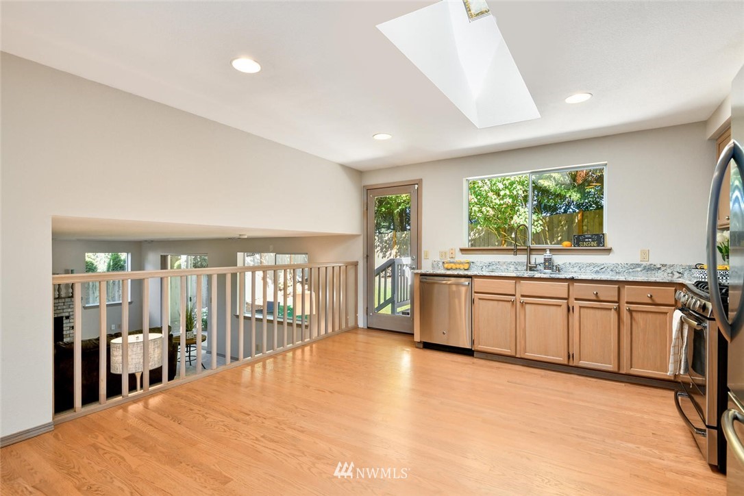 3225 208th Place Southeast Bothell, WA 98021 - Photo 8 of 28 a kitchen with stainless steel appliances granite countertop a stove a sink dishwasher a refrigerator with white cabinets and wooden floor