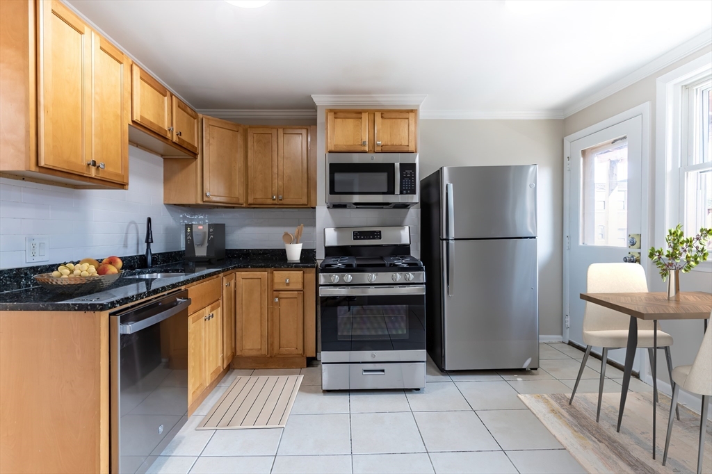 59-61 Division Street Chelsea, MA 02150 - Photo 2 of 13 a kitchen with stainless steel appliances granite countertop a refrigerator stove and a sink