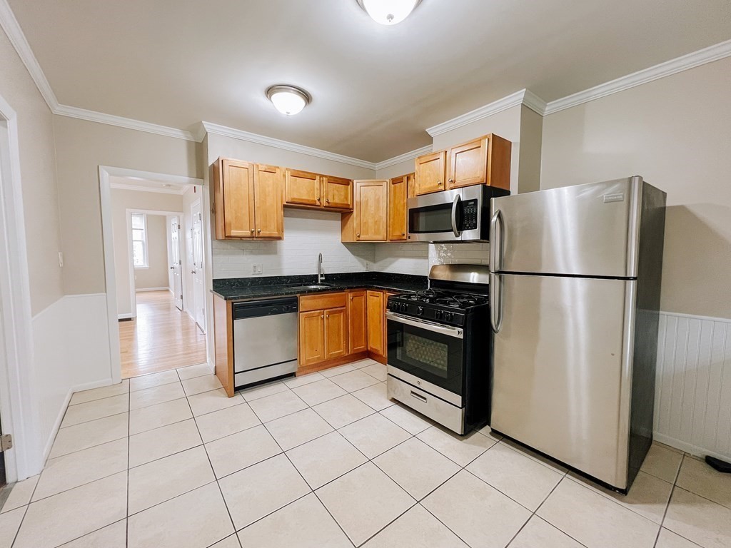 59-61 Division Street Chelsea, MA 02150 - Photo 8 of 13 a kitchen with stainless steel appliances granite countertop a refrigerator sink and stove