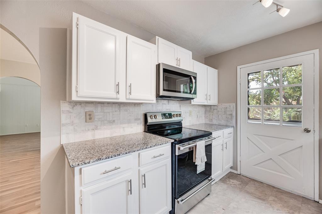 2002 Rose Hill Road Carrollton, TX 75007 - Photo 15 of 34 a kitchen with stainless steel appliances granite countertop white cabinets granite counter tops and a window