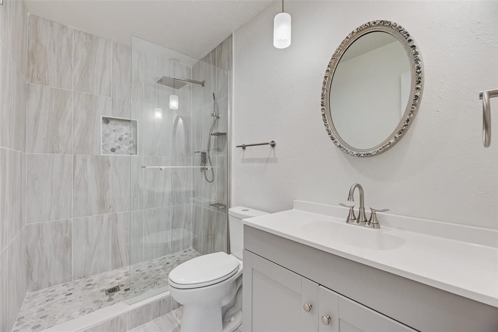 2002 Rose Hill Road Carrollton, TX 75007 - Photo 20 of 34 a bathroom with a sink a toilet and a mirror