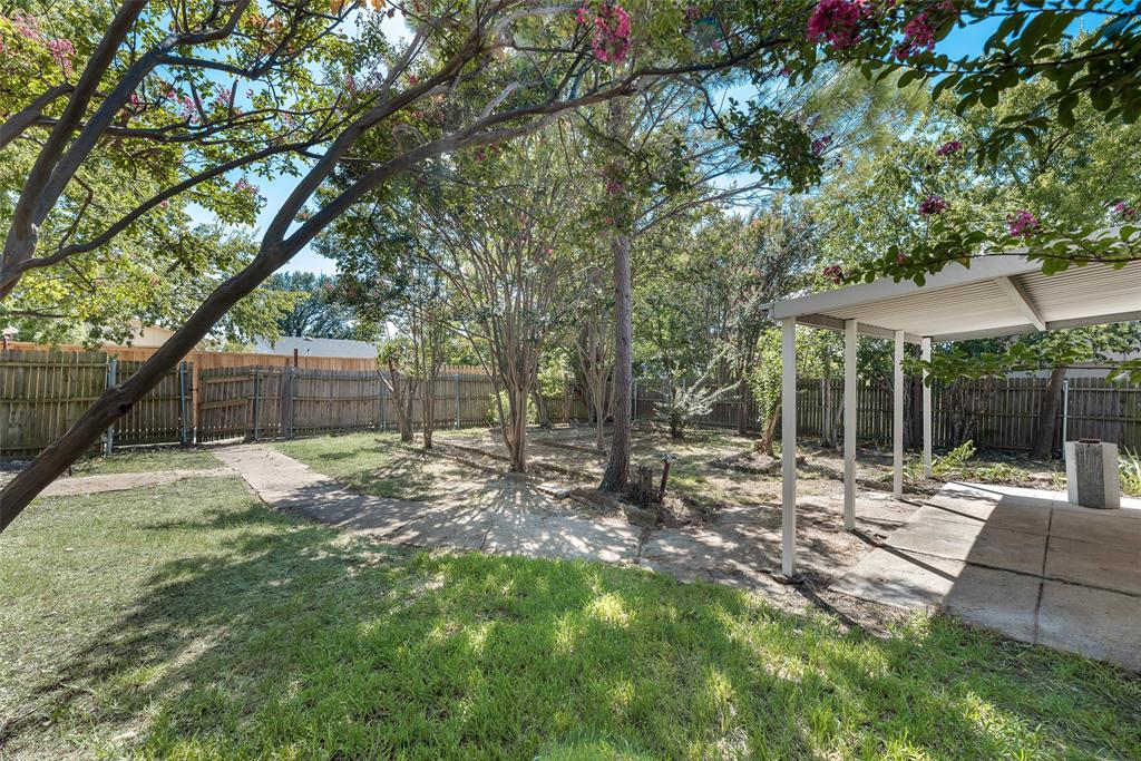 2002 Rose Hill Road Carrollton, TX 75007 - Photo 30 of 34 a view of a backyard with table and chairs under an umbrella