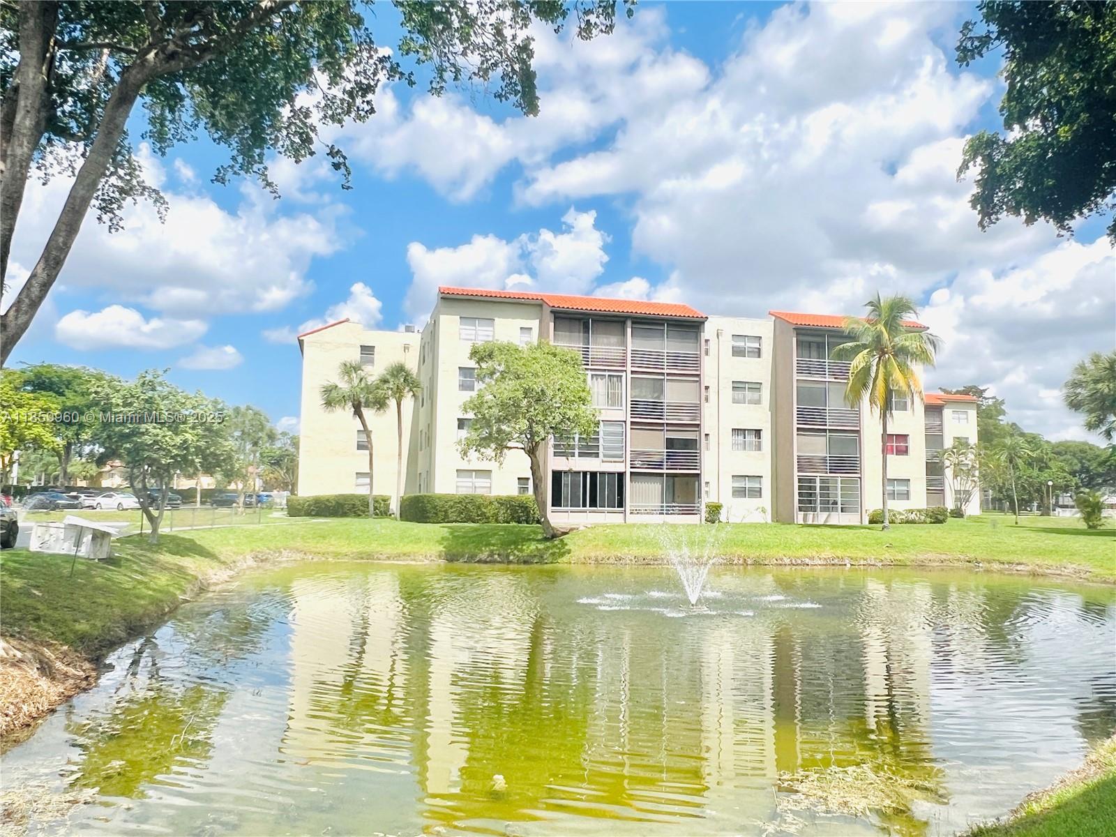 1810 Southwest 81st Avenue, Unit 2201 North Lauderdale, FL 33068 - Photo 2 of 32 a view of a lake with a big yard and large trees