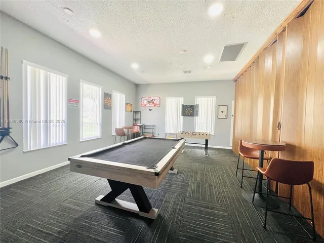 a living room with furniture pool table and a large window