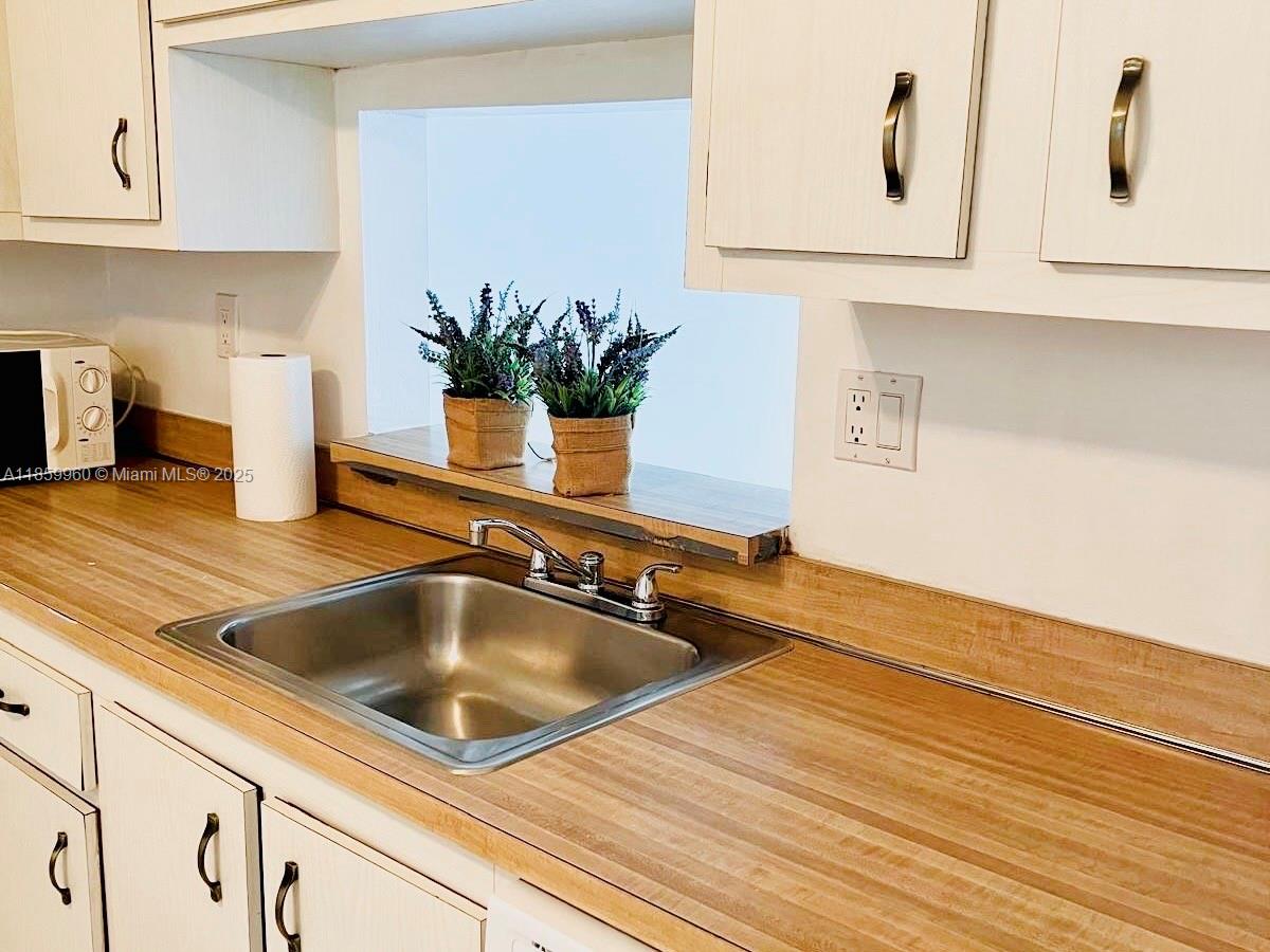 1810 Southwest 81st Avenue, Unit 2201 North Lauderdale, FL 33068 - Photo 6 of 32 a kitchen with kitchen island a counter top space and cabinets
