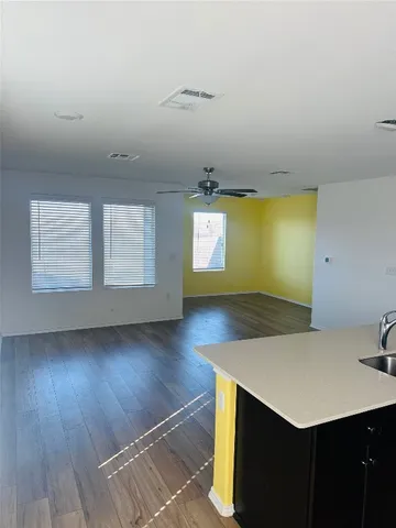 a view of kitchen and empty room with windows