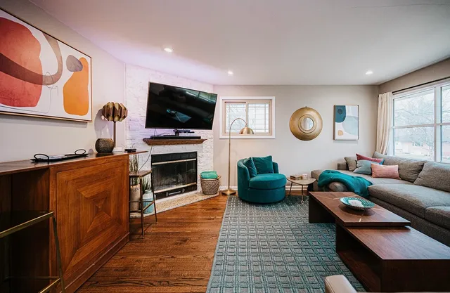a living room with furniture a flat screen tv and a fireplace