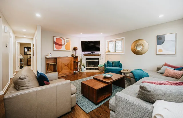 a living room with furniture a flat screen tv and a fireplace