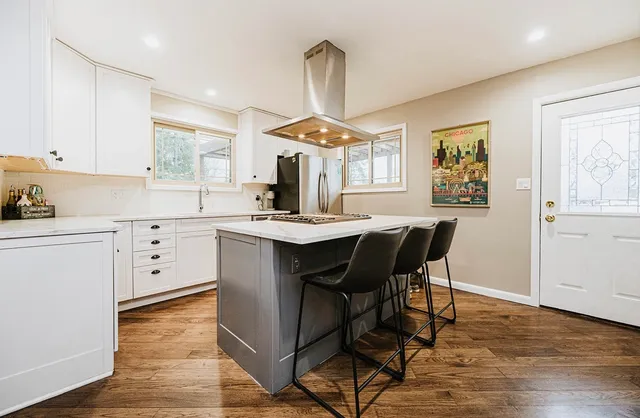 a kitchen with a table chairs a sink dishwasher window and cabinets