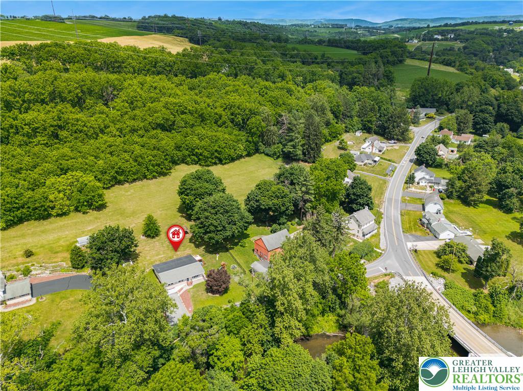 50 Kohls Road Northampton, PA 18067 - Photo 45 of 54 An aerial panorama reveals a peaceful rural landscape with a quaint home nestled amongst verdant trees and open fields.