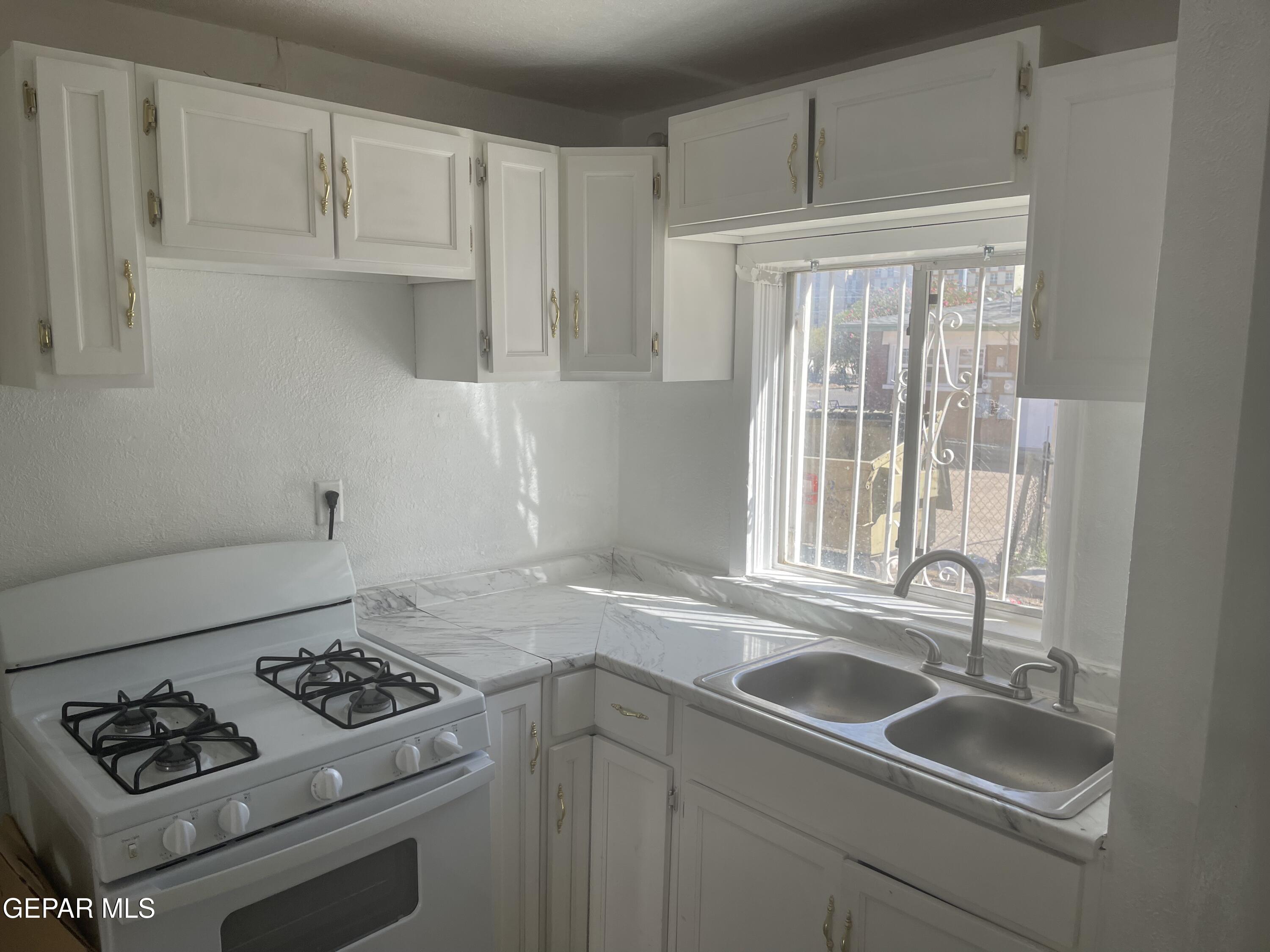 1026 Myrtle Avenue, Unit 6 El Paso, TX 79901 - Photo 3 of 7 a kitchen with sink a stove and cabinets