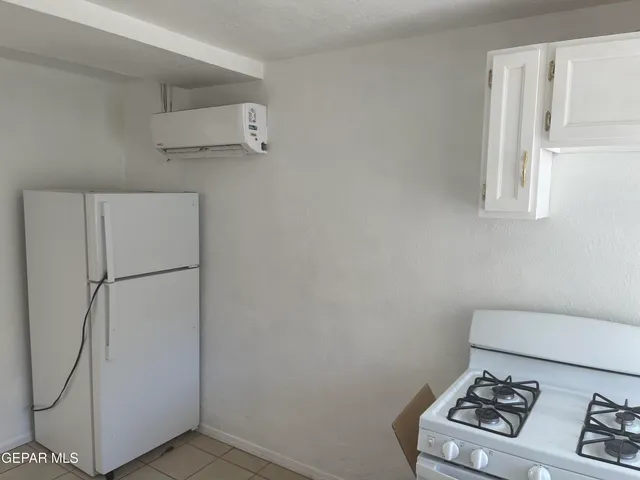 a white refrigerator freezer and a stove sitting inside of a kitchen