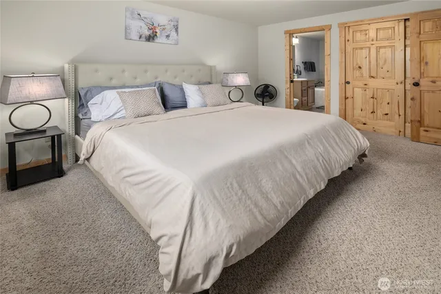 a spacious bedroom with a bed and painting on the wall