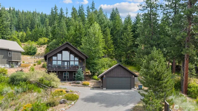 a view of a house with a small yard plants and large tree