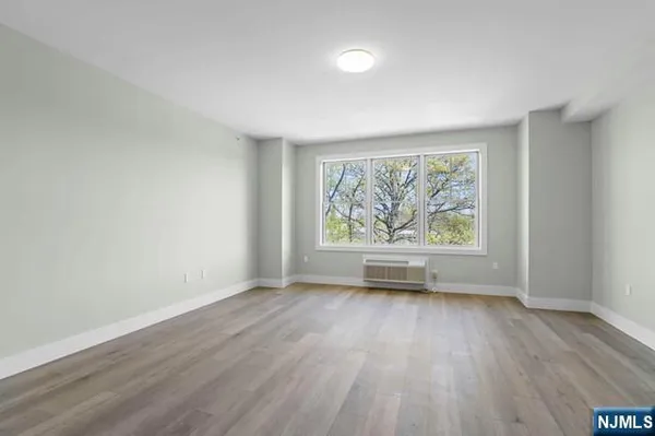 an empty room with wooden floor and window