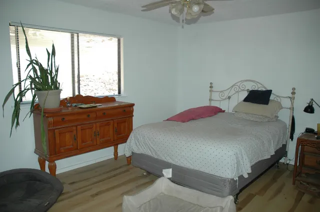 a bedroom with a bed and a flat tv screen on dresser