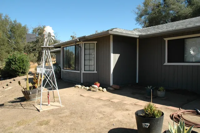 a view of a backyard with chair and potted plants