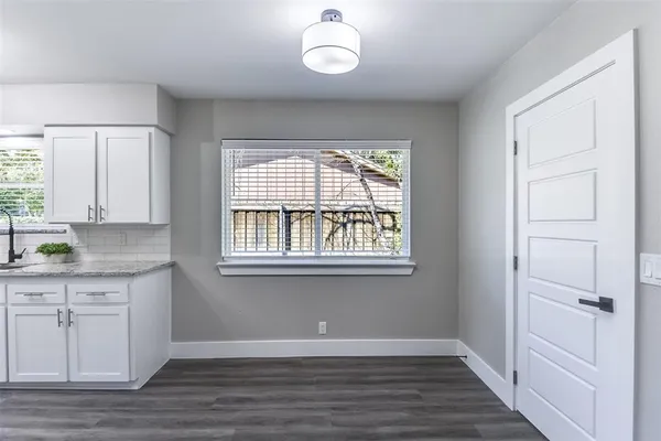 a view of an entryway with wooden floor and cabinet