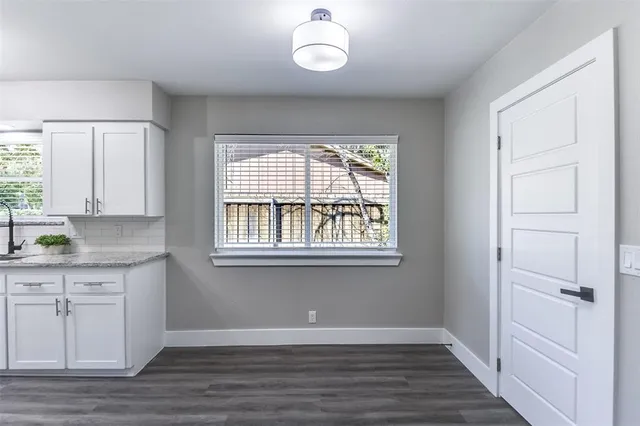 a view of an entryway with wooden floor and cabinet